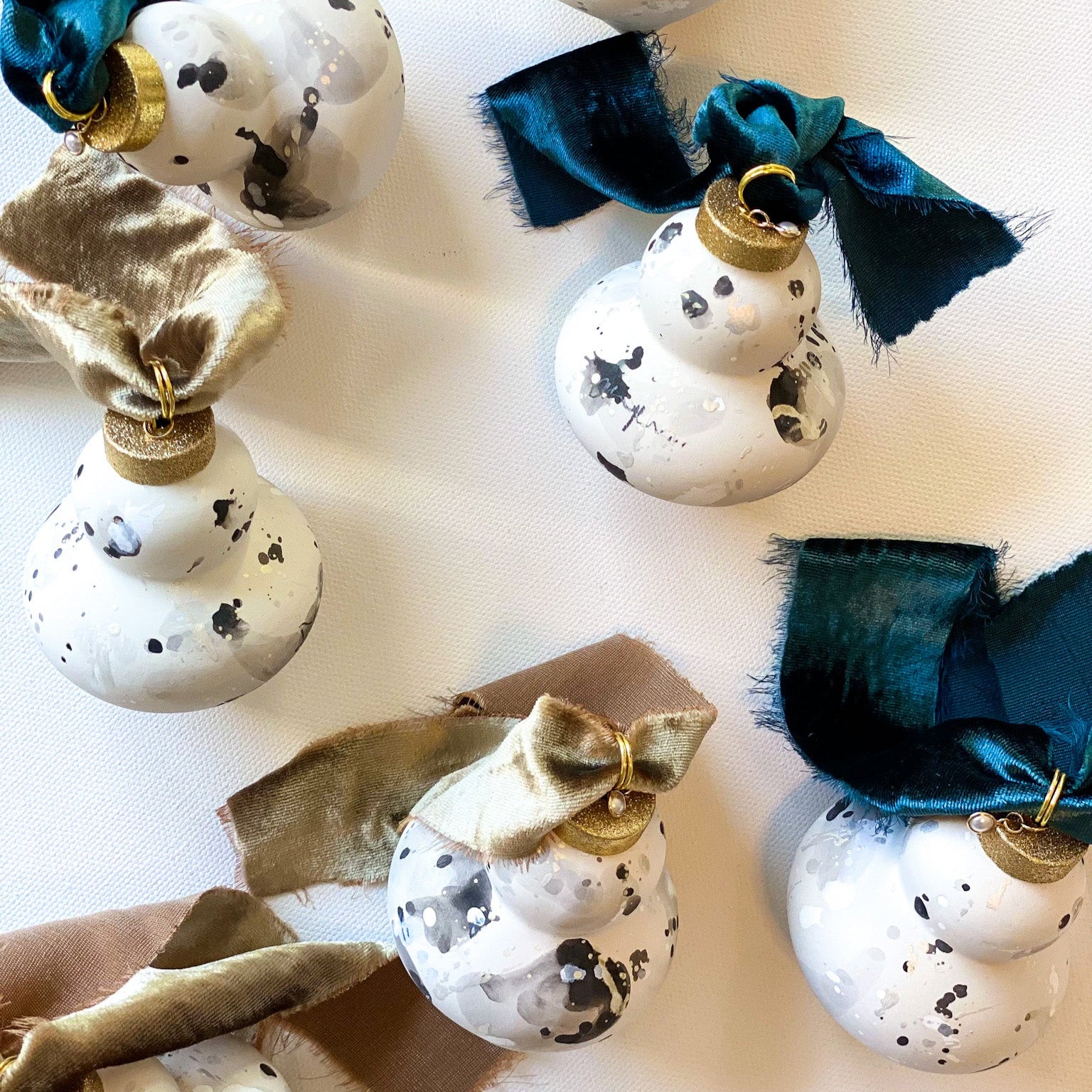 Decorative Christmas ornaments with gold and blue ribbons on ceramic bisque