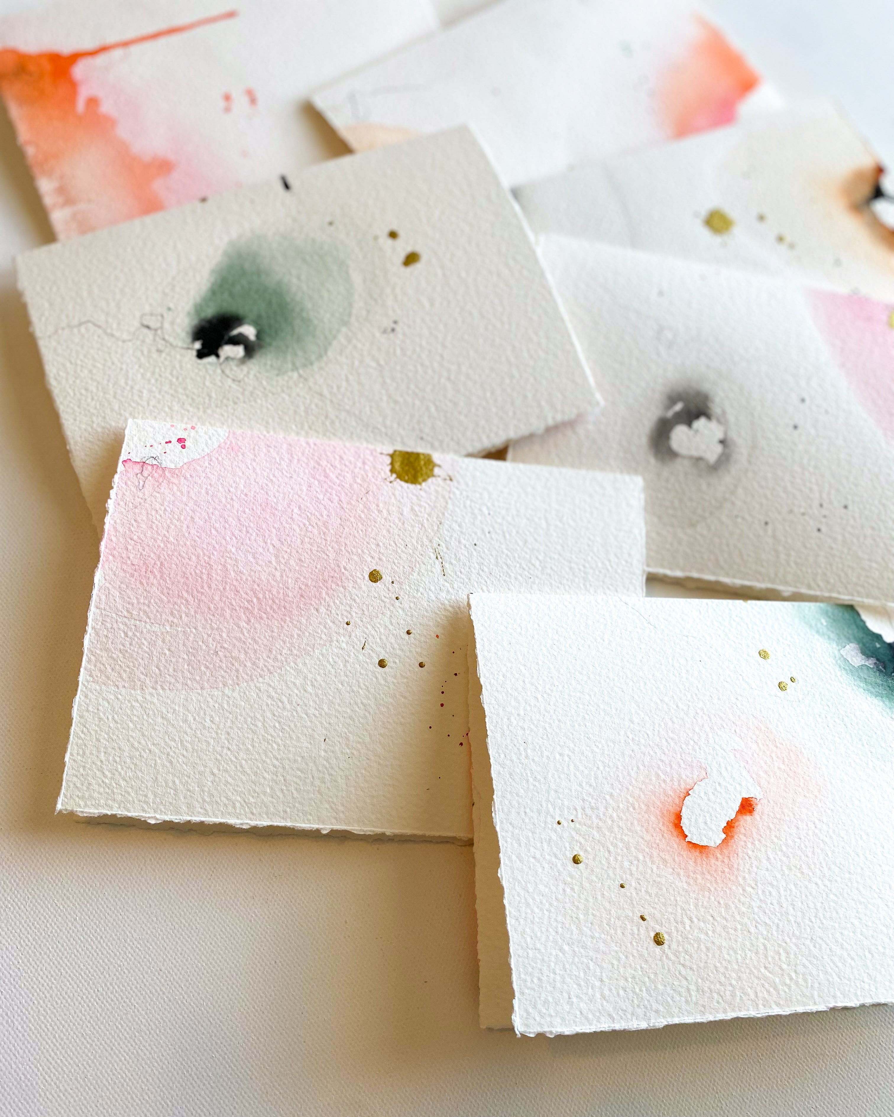 Square watercolor samples with various colors on a beige background