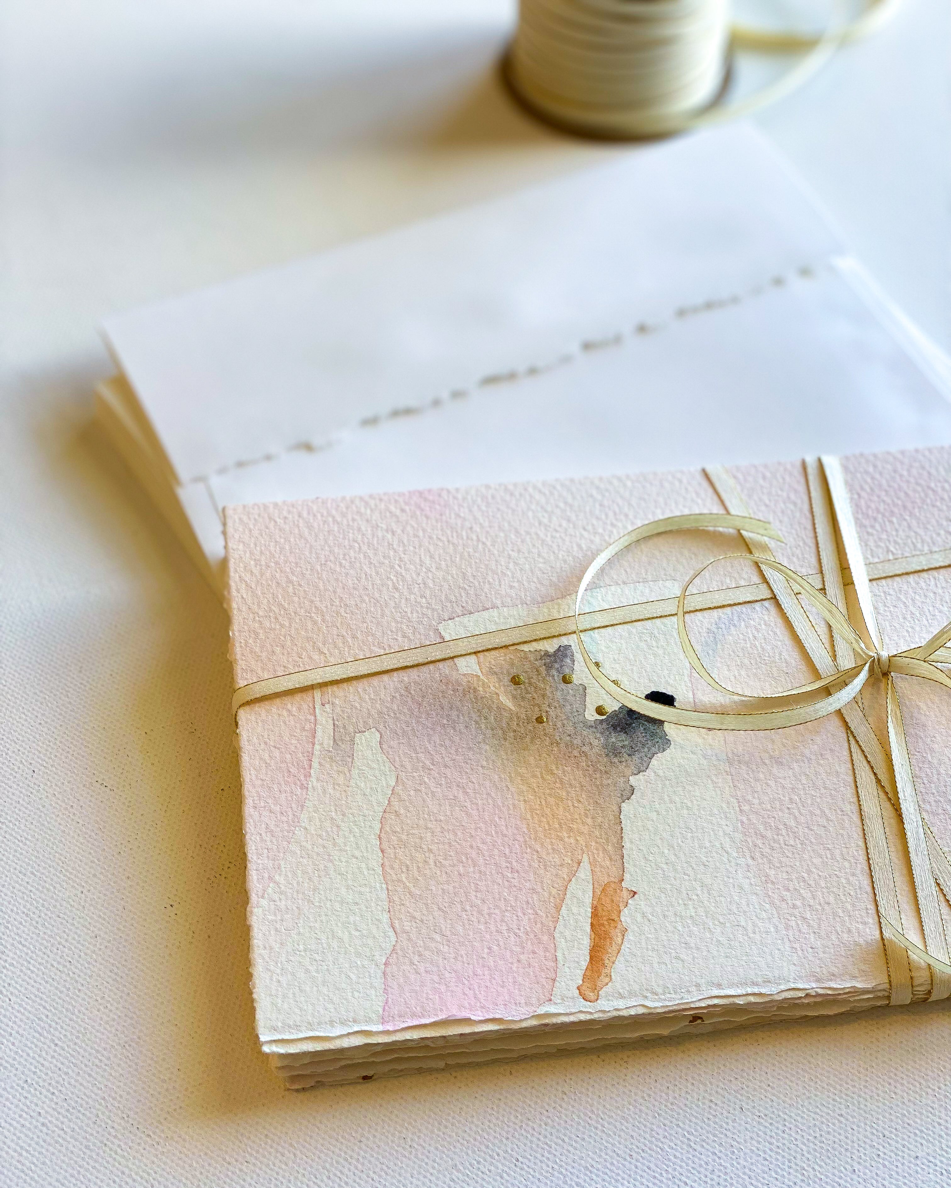 Gift card with floral design and gold ribbon on a white surface