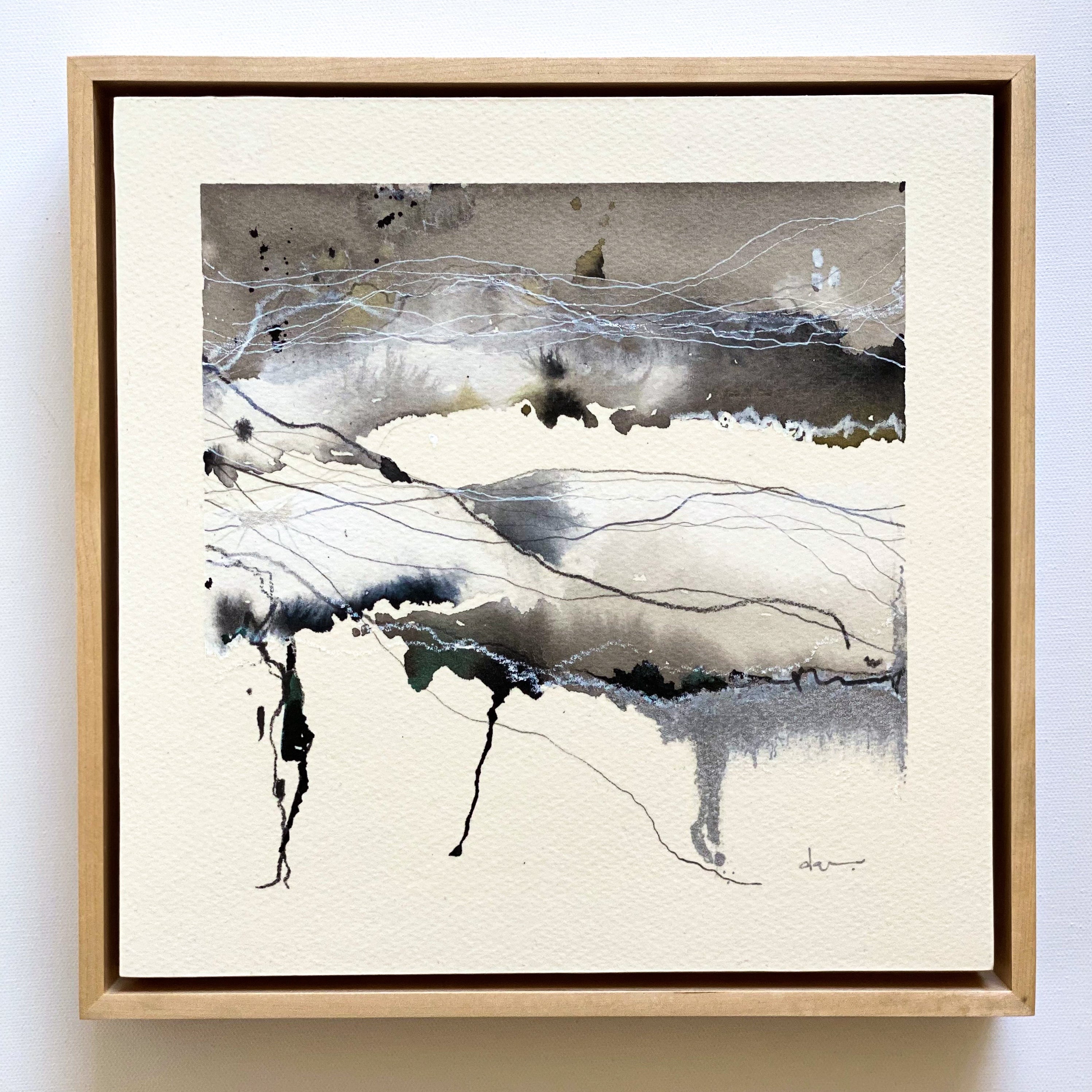 Framed abstract art piece with black, white, and gray colors on a light background