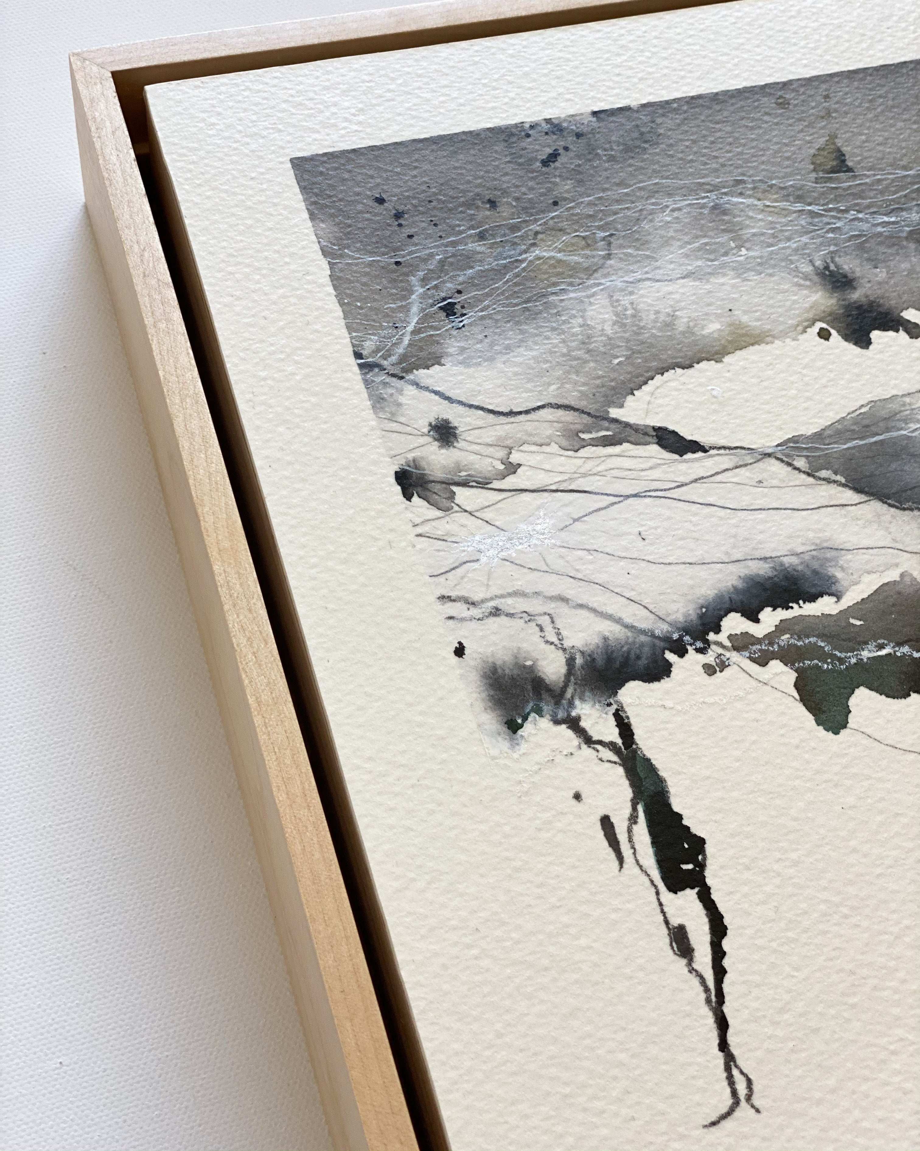 Framed abstract artwork with black and white brush strokes on a light background
