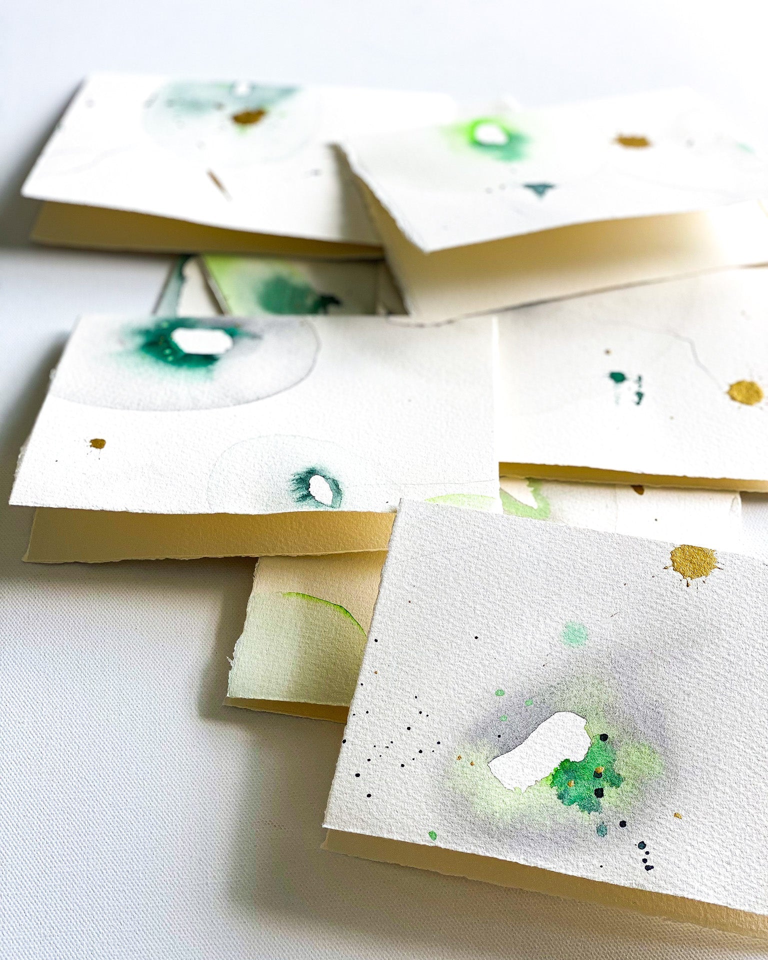 Stationery with green watercolor designs on a white watercolor paper