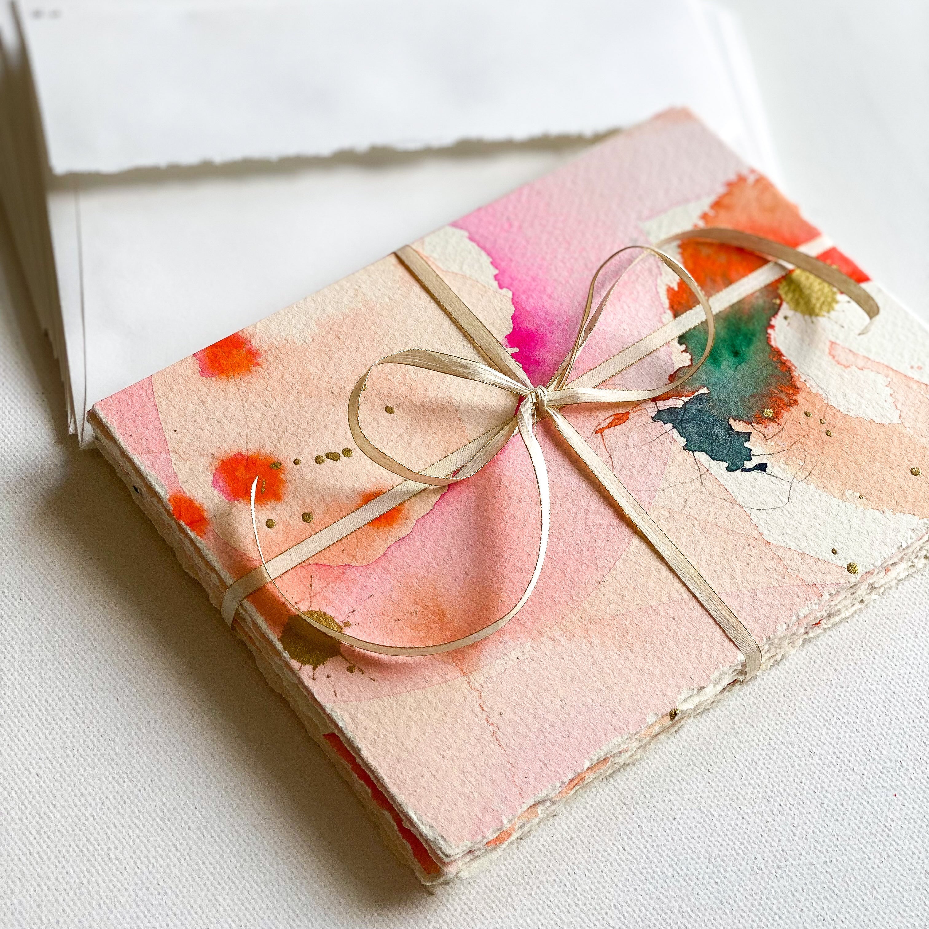 Notebook with watercolor cover and ribbon on a white background