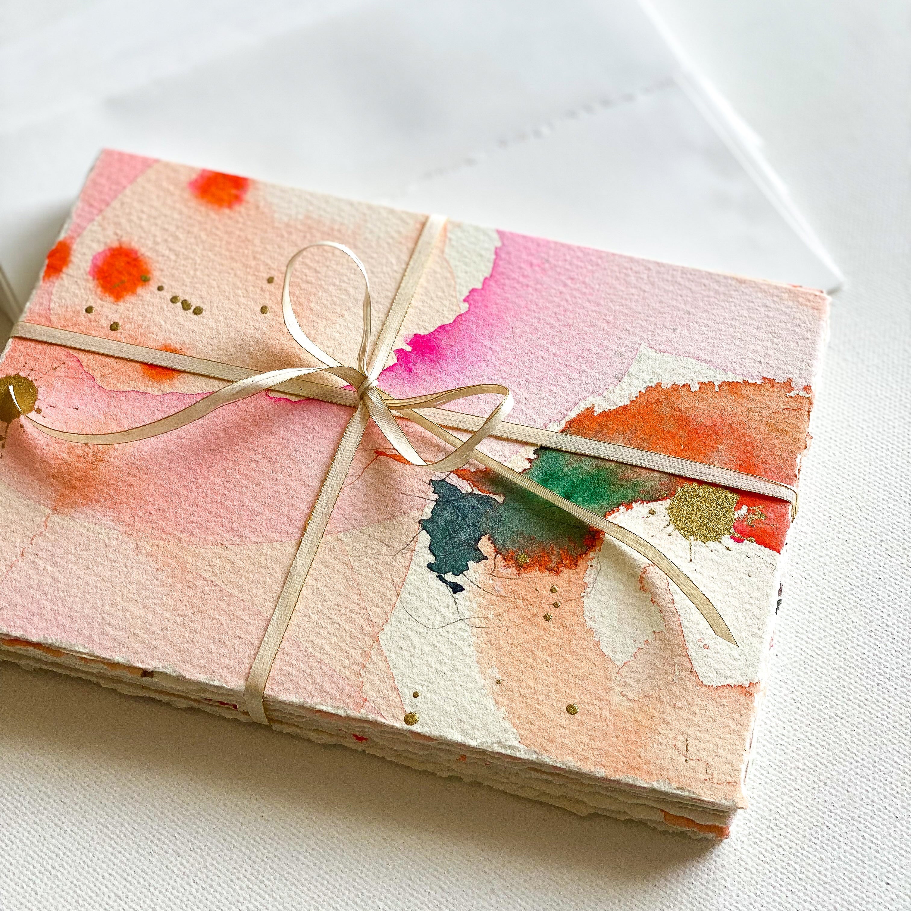 Gift box with watercolor design and ribbon on a white background